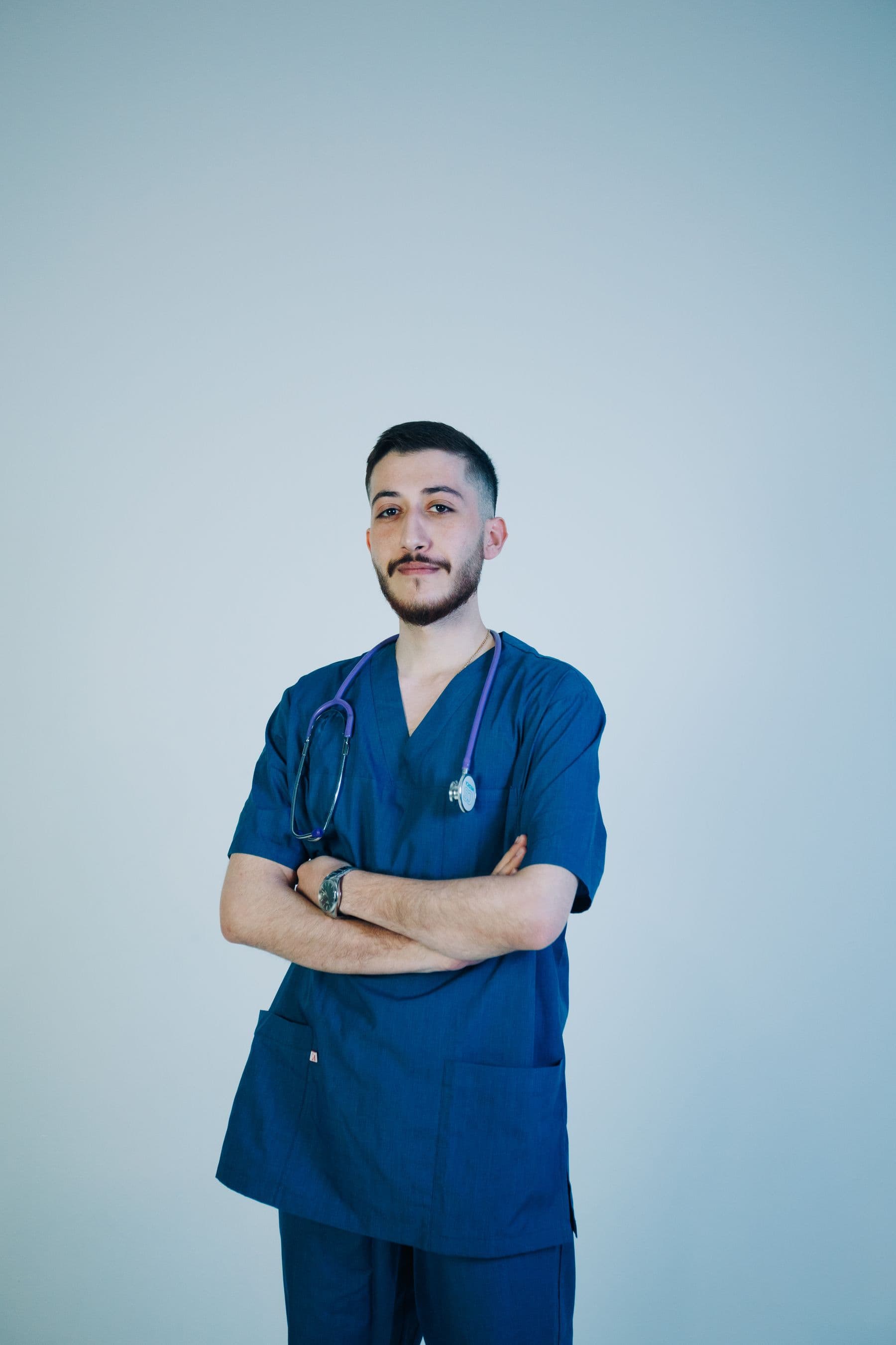 Sports practitioner in scrubs with arms crossed